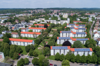 Sanierte, weiße Wohnhäuser mit Satteldächern und Solarpanels, 3 und 4 Etagen. Rundum Wiesen und Bäume. Sanierte, weiße Wohnhäuser mit Satteldächern und Solarpanels, 3 und 4 Etagen. Rundum Wiesen und Bäume.