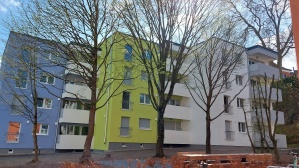 Gebäude mit vier Wohnetagen mit blauer und grüner Fassade