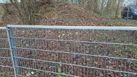 Böschung und Hecke vor der Reinigung, Gitter im Vordergrund