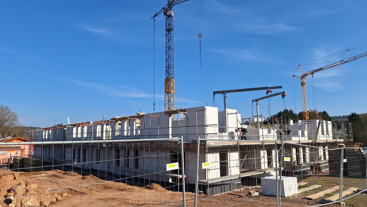 Seitenaufnahme 1. Gebäude mit Erdgeschoss, Mauern 1. Etage, hinten Baukran.